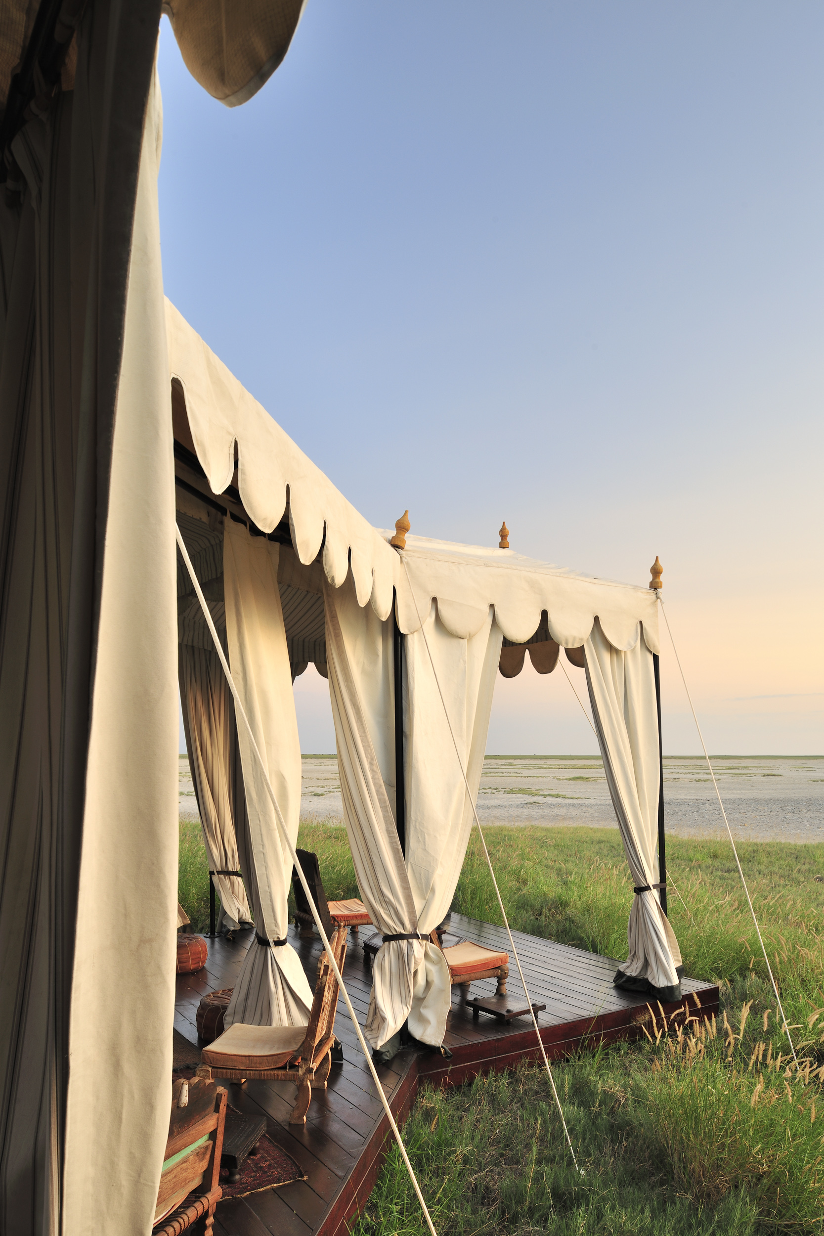 A luxurious open tent set against an expansive landscape, perfect for relaxation with stunning views.