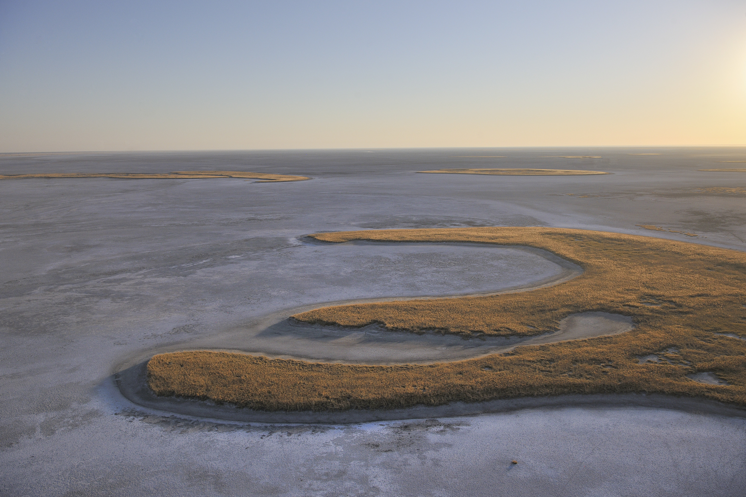 The ethereal beauty of Botswana’s salt pans at sunrise captured from above—true wilderness luxury.